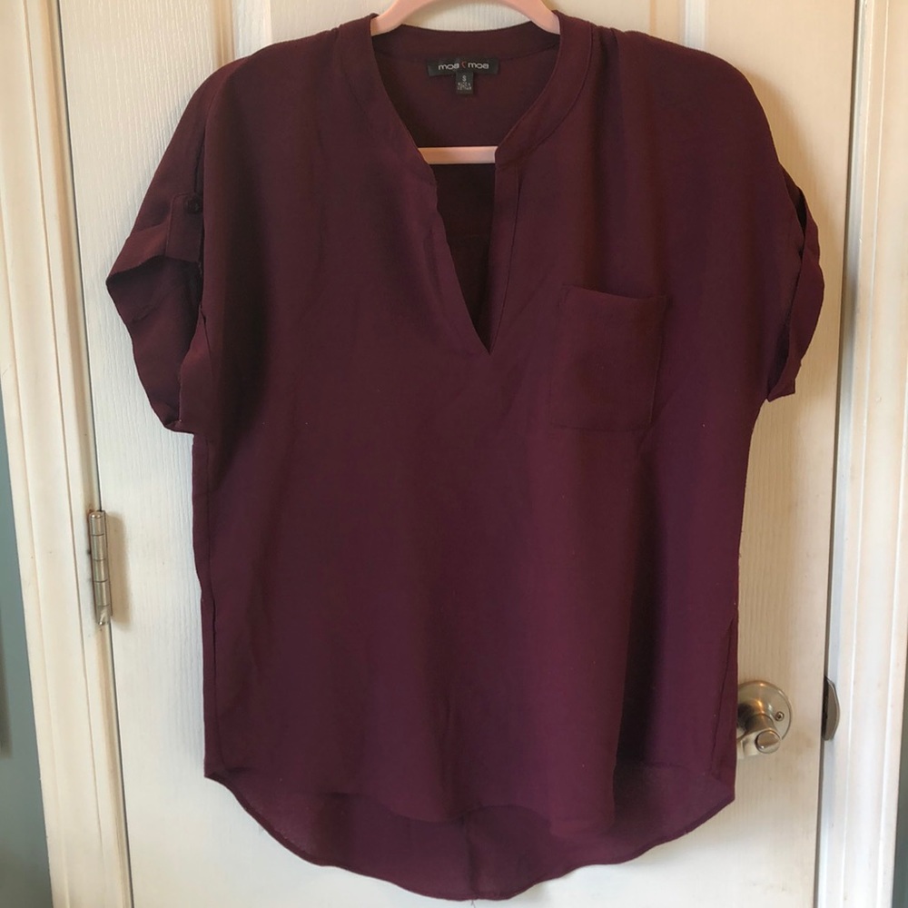 Collarless blouse with front pocket.